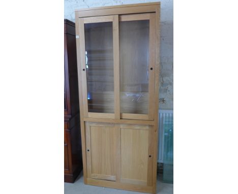 A light oak bookcase of two glazed doors over two panel doors - 92cm x 33cm x 215cm 
