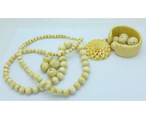 An antique carved ivory pendant, beads and a bangle 