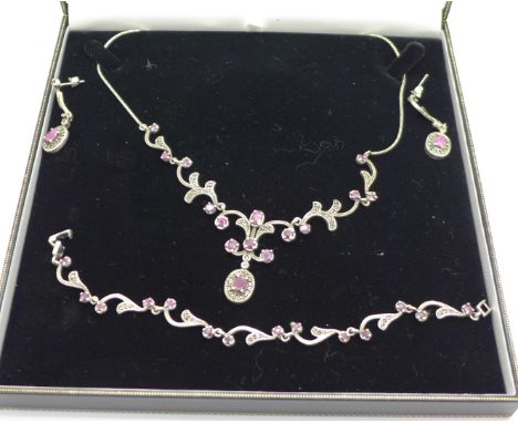 A silver, ruby and marcasite necklace, bracelet and earrings, boxed 