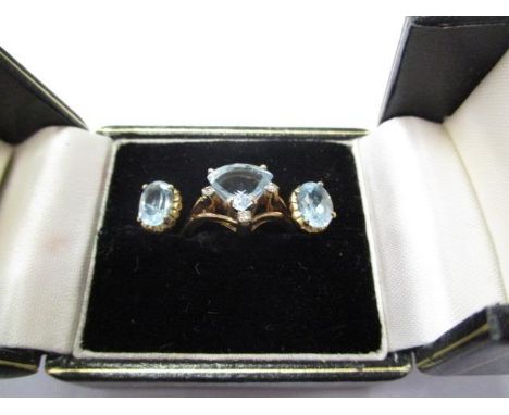 A 9ct gold aquamarine ring set with a quadrant shaped aquamarine with three small diamonds, together with a pair of aquamarin