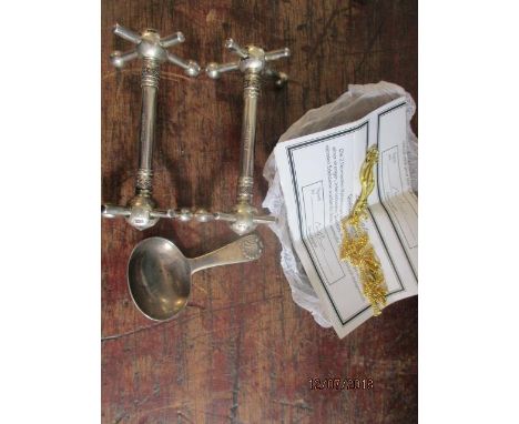 A George III silver tea caddy spoon and a pair of Victorian silver knife rests, along with a gold plated pendant and chain 