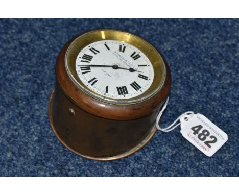 A SMALL CLOCK SWISS MADE FOR S.SMITH &amp; SON LTD. 8-day motor clock in brass case, stamped 370, with key, enamel dial, blac