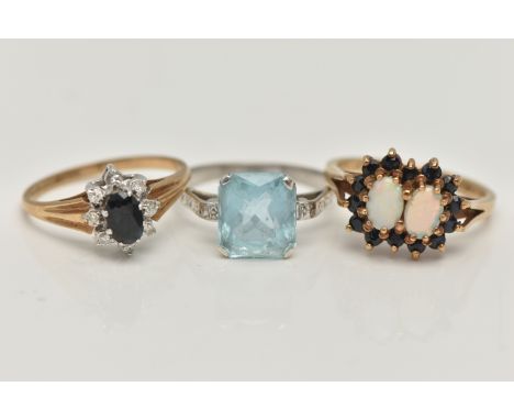 THREE GEM SET RINGS, the first a 9ct yellow gold, double cluster ring, set with two oval cut opal cabochons, each claw set wi