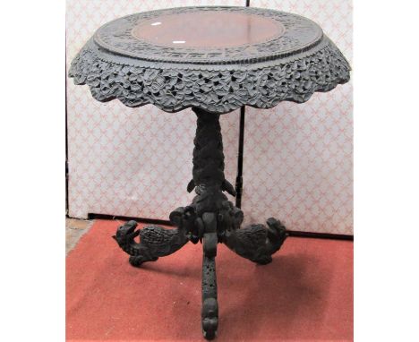 A 19th century Indonesian hardwood occasional table with circular top and carved and pierced borders, raised on a pierced and