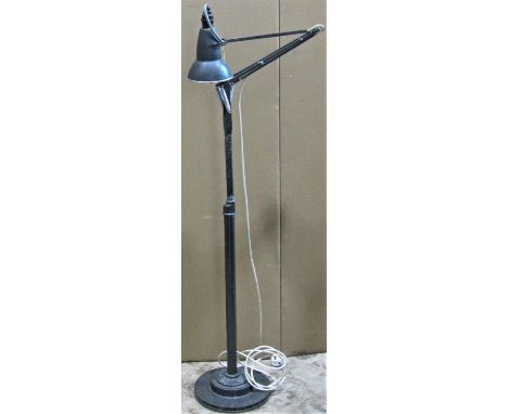 An industrial floorstanding light with Herbert Terry anglepoise lamp raised on an associated tubular steel stem and stepped d