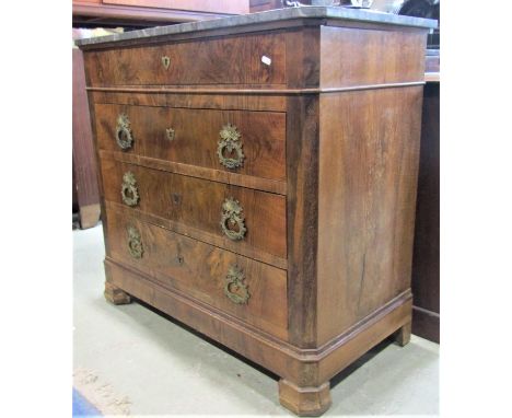 A 19th century figured walnut veneered commode of four long drawers with cast gilt metal drop handles and shield shaped escut