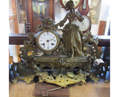 19th century gilt brass mantel clock in the romantic style, with female character floral bouquets, etc, raised on a shaped an
