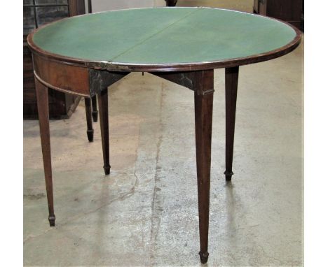 A Georgian mixed wood demi-lune foldover top card table with moulded outline raised on four slender square tapered legs and s