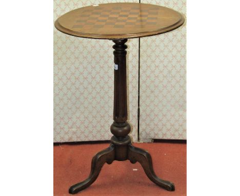 A Victorian mahogany games table, the circular top with chequered board detail, raised on turned and fluted column and tripod