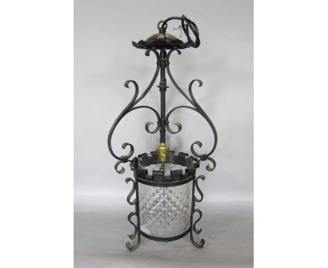 An arts and crafts gothic style hall lantern with wrought iron frame and moulded cylindrical glass shade with castellated det