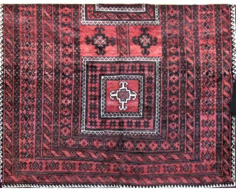 Good old Balouchi carpet, with typical central block medallions upon a washed red ground, 255 x 150 cm 