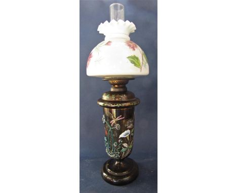 An unusual enamelled glass oil lamp base, decorated in relief with insects amidst foliage, further glass shade and flue, 65 c