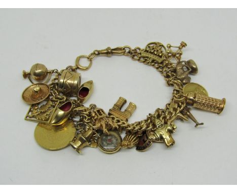 Good 18ct curb link charm bracelet hung with twenty-two novelty charms to include an owl with ruby eyes, Leaning Tower of Pis