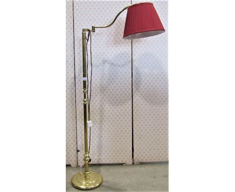 A brass coated floorstanding reading lamp with knopped tubular stem and adjustable swan neck supporting a pleated shade and r