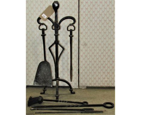 An Arts &amp; Crafts style iron work companion set together with four further fire tools 