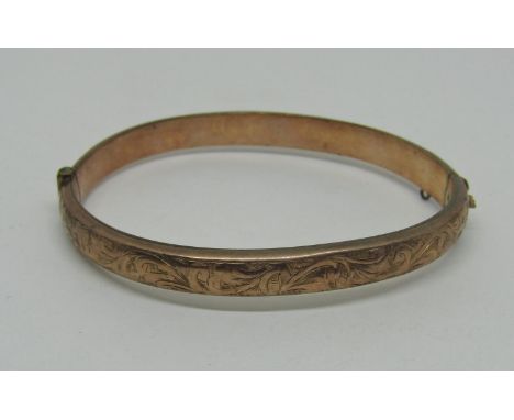 9ct hinged bangle with engraved scrolled decoration, 10.2g (dented) 