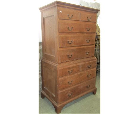 A small Georgian style light oak two sectional chest on chest, fitted with an arrangement of nine drawers with brass swan nec