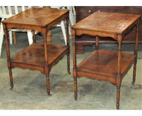 A pair of small reproduction yewwood veneered two tier side/lamp tables of rectangular form raised on ring turned and tapered