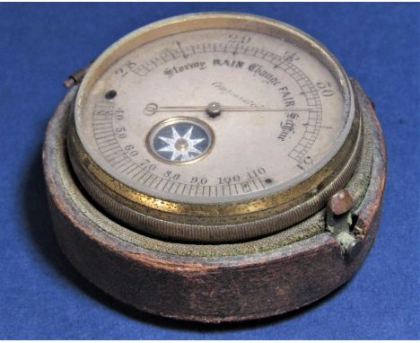 A 19th century pocket mounted barometer enclosing a small compass with paper label - mounted barometer table from the baromet