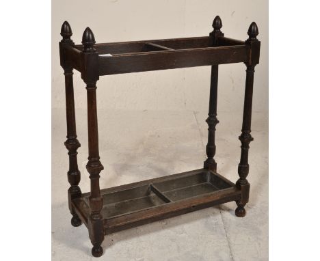 A Victorian 19th century carved oak stick / umbrella stand having twin sections with turned column supports and finial tops w