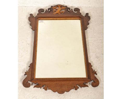 An Edwardian mahogany pier mirror having upright mirror panel in shaped mahogany frame with pierced and gilded eagle decorati