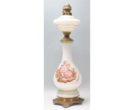 A 19th Century Victorian milk glass and brass oil lamp having a transfer printed classical courting scene raised on a brass s