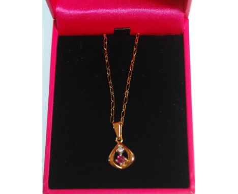 An 18ct gold pendant necklace having a tear drop pendant set with a round cut ruby and diamond. Chain and pendant marked 750.