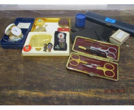 An Estee Lauder Taurus powder compact and others, a Halcyon Days enamelled bedside clock, retro Golly badges, snakeskin effec