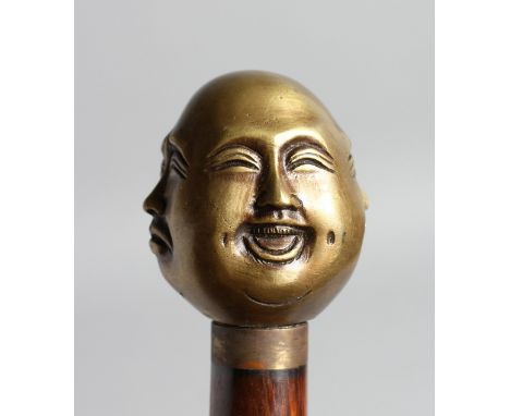 A WALKING STICK with carved bone handle of four child's faces.