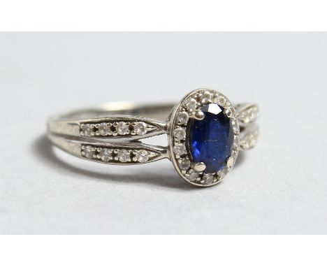 A 9CT WHITE GOLD SAPPHIRE AND DIAMOND CLUSTER RING.