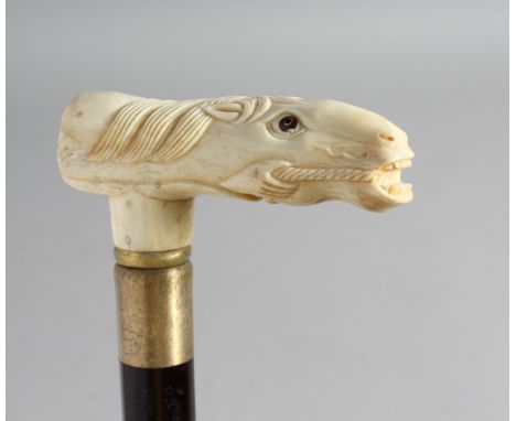 A WALKING STICK with carved bone handle of a horse.