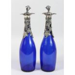 A PAIR OF BRISTOL BLUE DECANTER BOTTLES with plated fruiting vines.