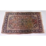 AN EARLY 20TH CENTURY PERSIAN RUG, rust ground with all over floral decoration. 7ft 2ins x 4ft