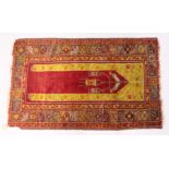 AN EARLY 20TH CENTURY ANATOLIAN PRAYER RUG, red ground with geometric design. 5ft 6ins x 3ft 4ins.