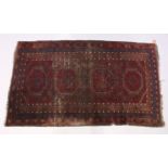 AN EARLY 20TH CENTURY PERSIAN RUG, red ground with stylized design (worn). 7ft x 4ft.