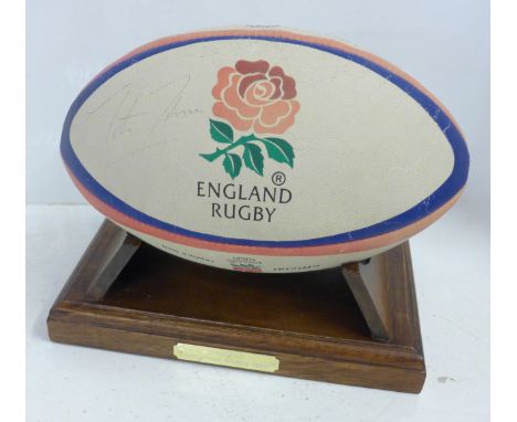An England Rugby ball, signed by Martin Johnson and two promotional black and white photographs of Jonny Wilkinson and Jason 