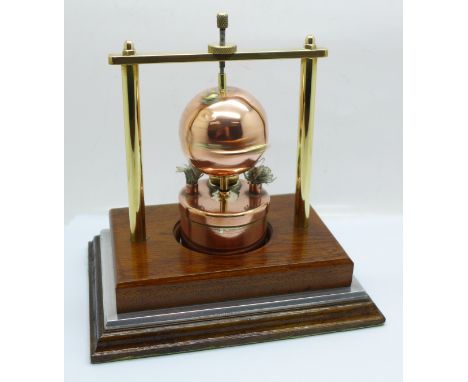 A steam driven copper Hero engine, mounted on a wooden plinth 