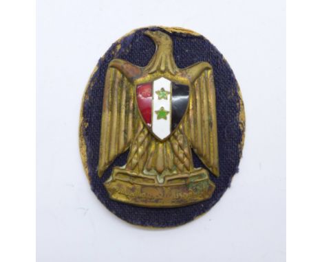 A Syrian army cap badge, (National Arms of Syria) 