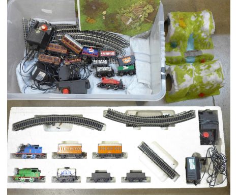 A box of model rail, two locomotives, carriages, a Thomas the Tank Engine and Percy train set 