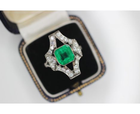 An Art Deco emerald and diamond ring, the central octagonal step cut emerald measuring 8.35mm x 8.25mm, set to a pierced geom