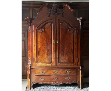 A large and impressive French Louis XVI style flame mahogany armoire, 19th century, the ornately carved pediment extending to