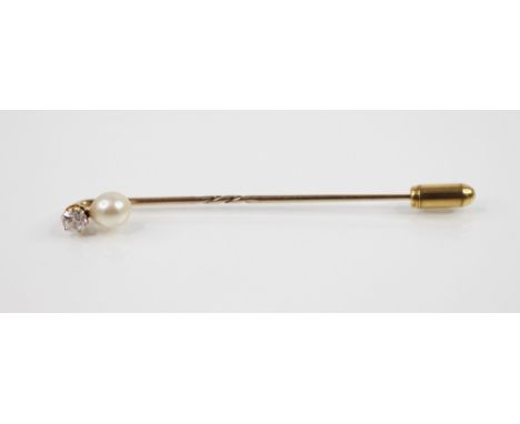 A diamond and pearl stick pin, comprising a round old cut diamond, estimated weight 0.15 ? 0.20 carats, suspending an off-rou