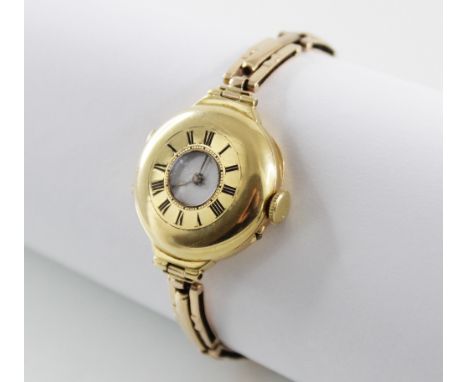 A lady's continental 18ct gold wristwatch, white enamel dial with black Roman numerals, half-hunter case with Roman numerals 