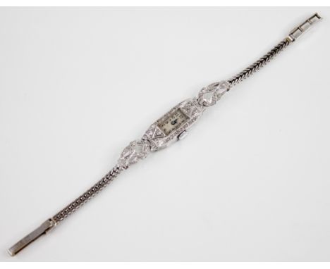 A lady’s diamond set cocktail watch, the platinum case measuring 23mm x 12mm, set with small single cut diamonds throughout, 