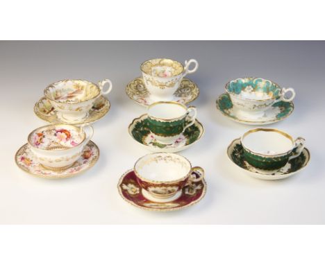 A Coalport Pembroke shaped teacup and saucer, circa 1827, decorated with polychrome landscape panels within gilt scrolled bor