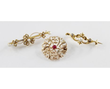 An Edwardian pearl set floral bar brooch, the central floral motif flanked by scrolling clovers, set with pearls throughout, 