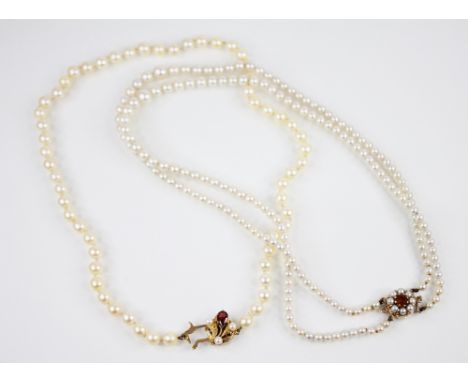 A cultured pearl necklace with a 9ct gold garnet set clasp, the single row of round cultured pearls each measuring 6mm diamet