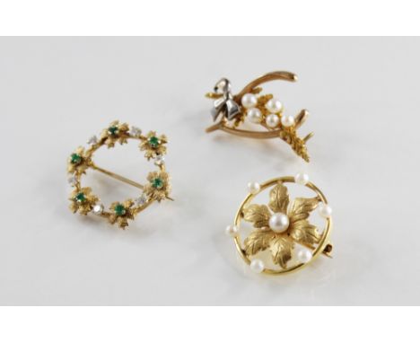 A 9ct gold diamond and emerald set garland brooch by Deakin &amp; Francis, comprising brilliant cut diamonds and mixed cut em