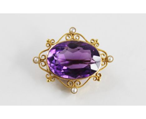 An amethyst and pearl set cluster brooch, comprising an oval mixed cut amethyst, 2.2cm x  1.7cm, set to a yellow metal scroll