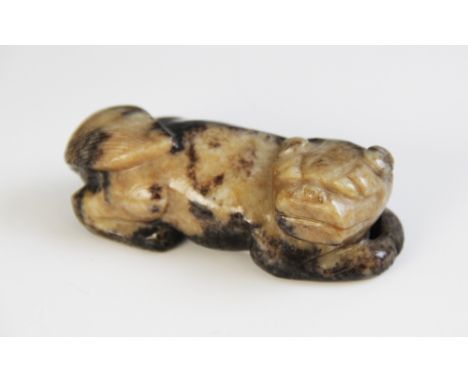 A Chinese jade carved dog, probably Western Han Dynasty, modelled in a recumbent position, 8cm wide
